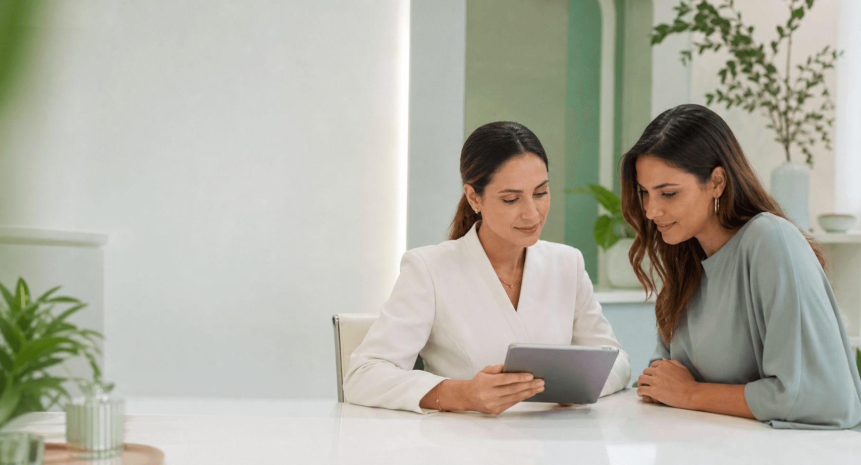 Profissional de clínica de estética e paciente consultando o prontuário eletrônico em um tablet